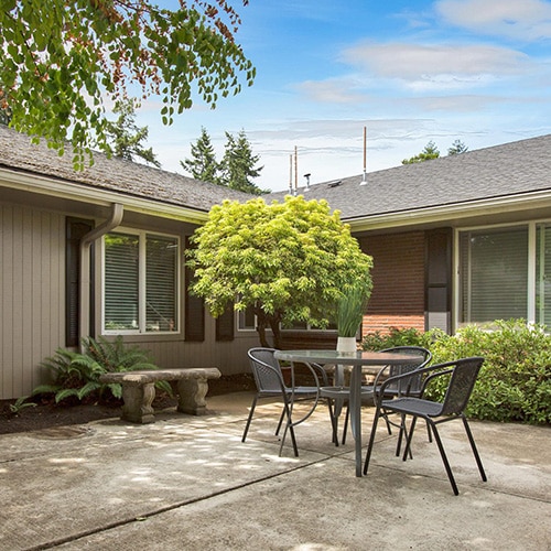 Courtyard with tables and plants at Porthaven Post Acute